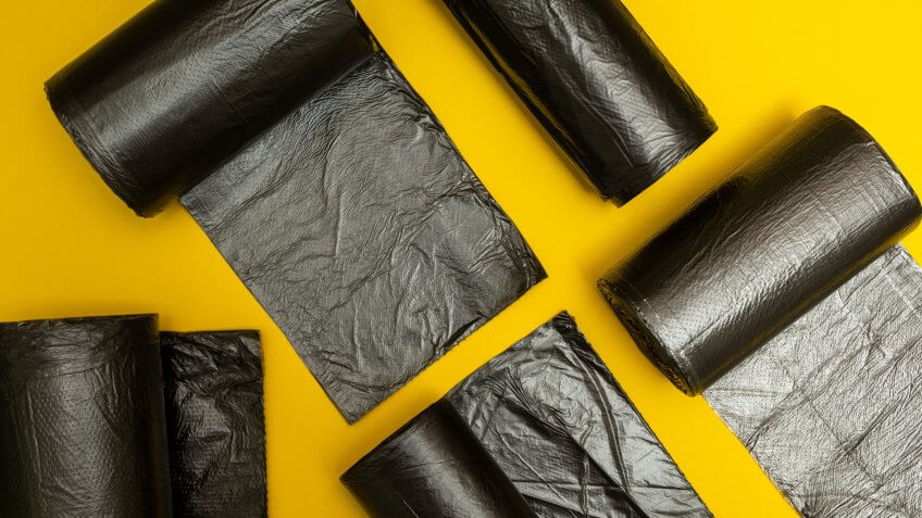 New black garbage bags on a yellow background.