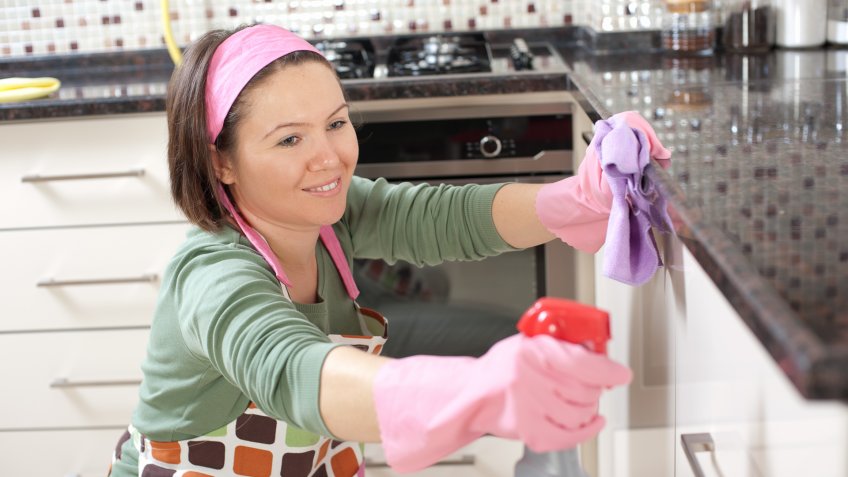 Happy woman is cleaning her home.