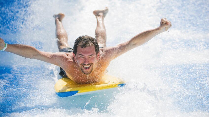 Man having fun laying on surfboard.