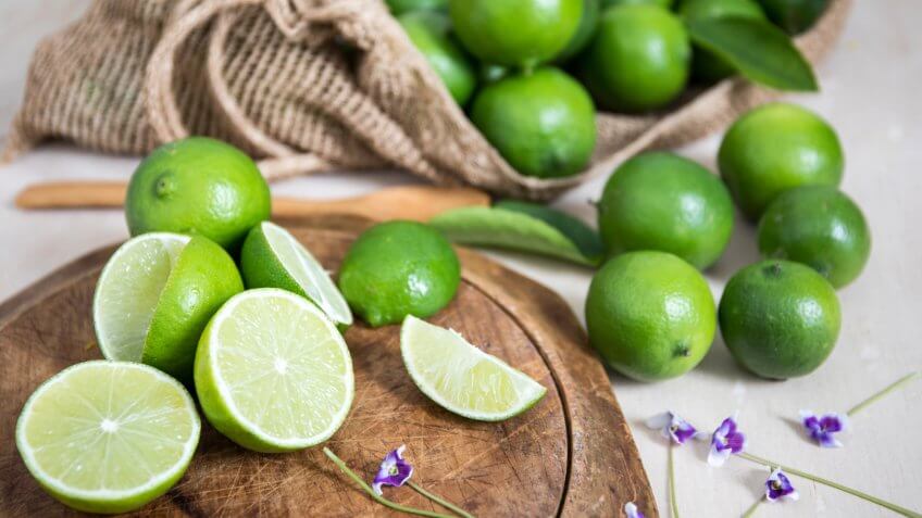 Lime citrus fruit on wooden board.