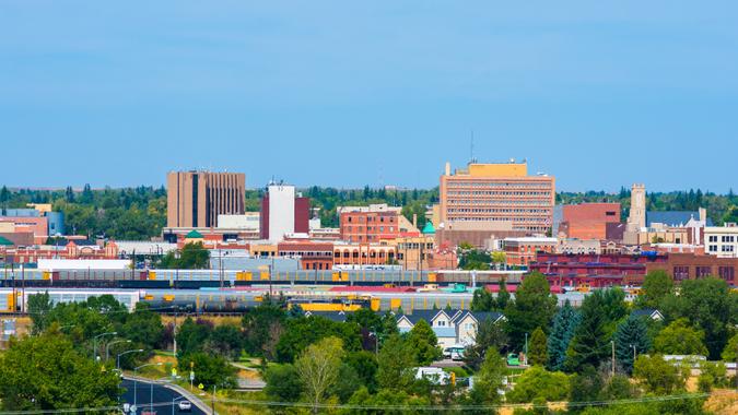 Cheyenne downtown skyline with train cars, houses, and trees in view.