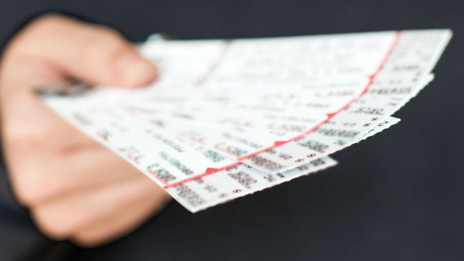  Tickets für eine Show / Veranstaltung in einer Hand mit schwarzem Hintergrund.
