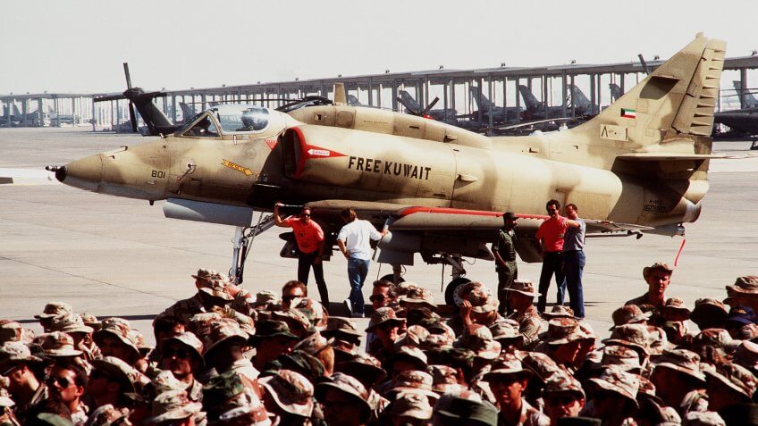 A Kuwaiti A-4KU Skyhawk aircraft sits parked on the fringes of a crowd that has gathered to listen to a speech by President George Bush.