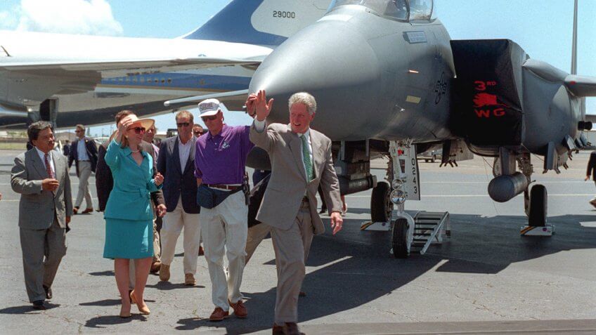 President William Jefferson Clinton and the First Lady wave as they walk across the runway for the commemoration of the 50th anniversary of the end of World War II.