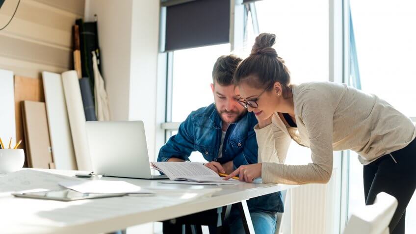 Two young people looking at paper document.