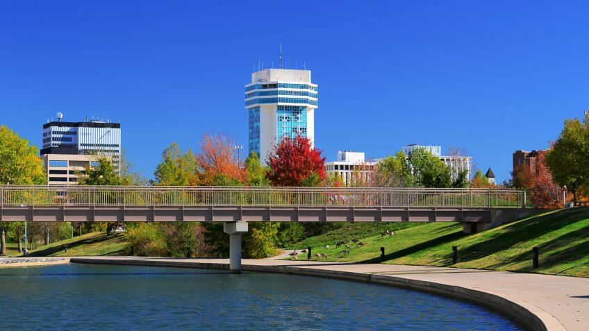 Downtown Wichita skyline with a waterway and park in the foreground.