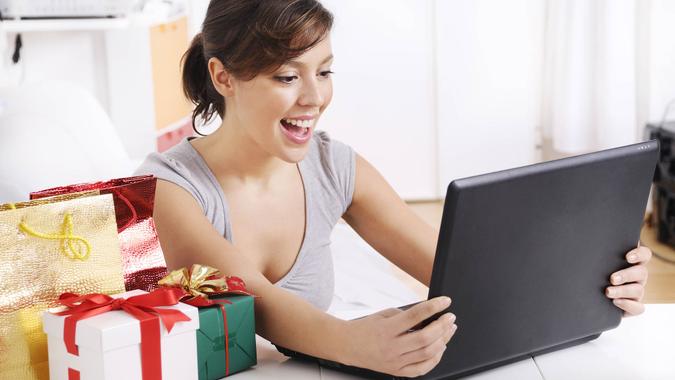 happy shopping on-line of young woman with laptop on internet.