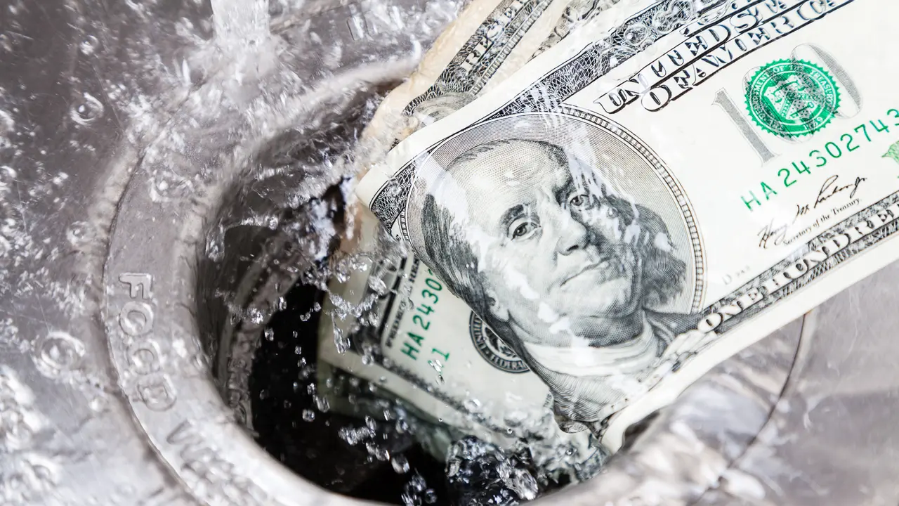 $100 dollar bill being washed down garbage disposal