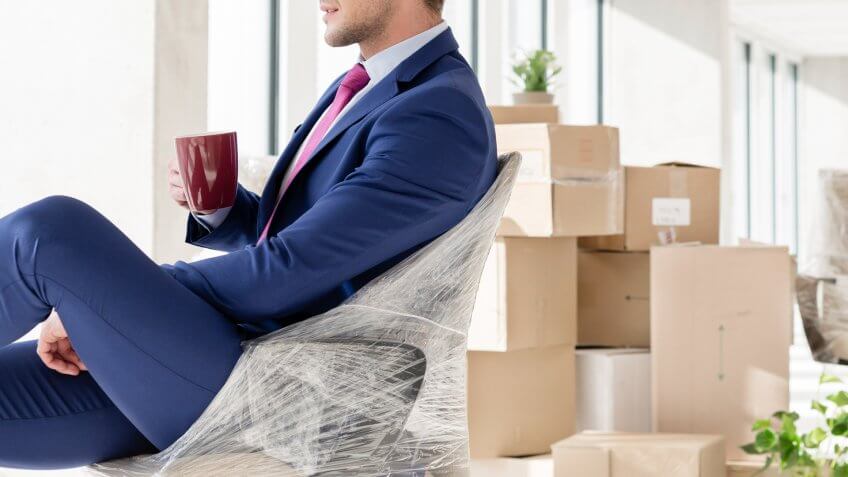 Businessman in office with moving boxes