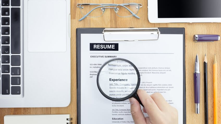 looking at resume with magnifying glass