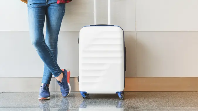 standing next to Luggage