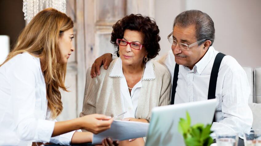 Financial consultant presents bank investments to a senior couple.
