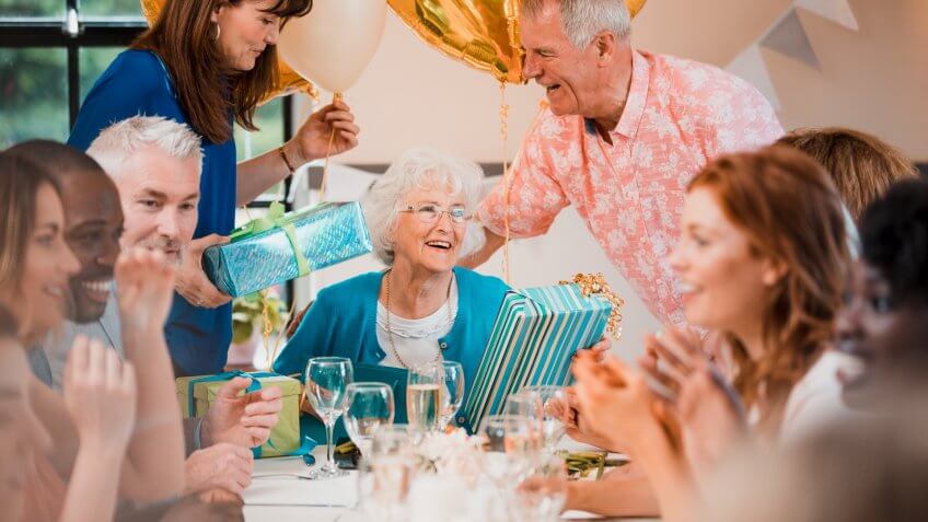 Senior woman is overwhelmed with emotion as she is surprised with a birthday party