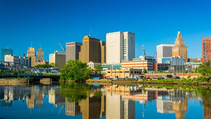 Newark downtown skyline with a mirror like reflection on the Passaic River in the foreground.