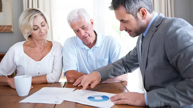 Shot of a financial advisor visiting a senior couple in their home.