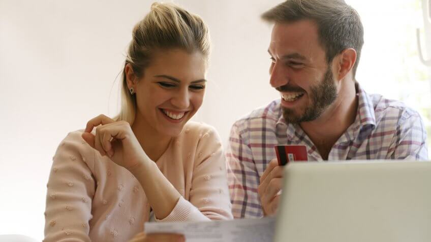 Cheerful family paying bills at home.
