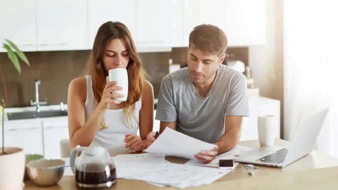 man sitting near his wife at kitchen showing her important document