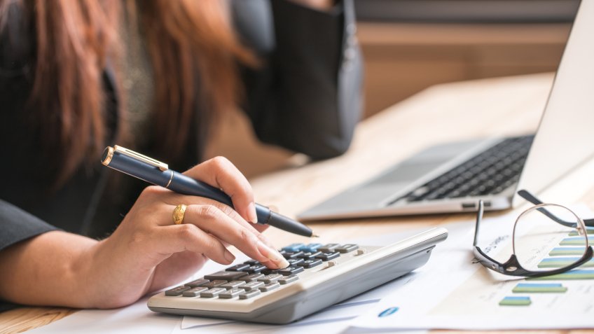 Close up of female accountant or banker making calculations.