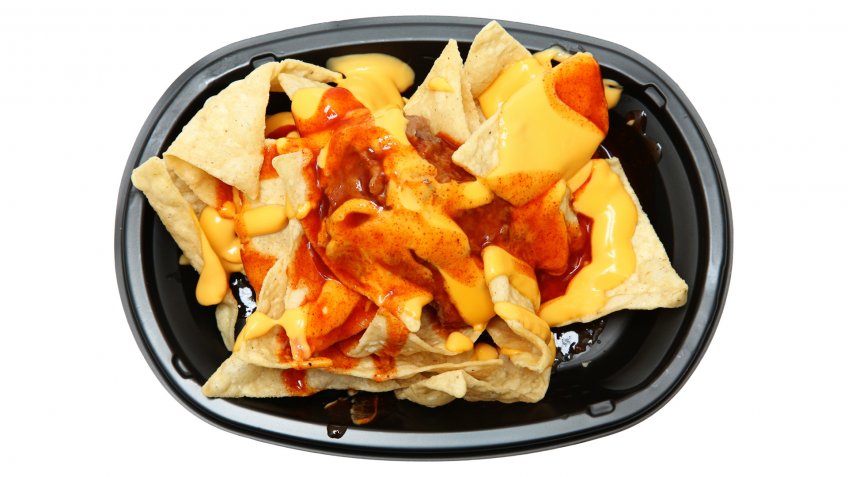 Triple layer nachos with tortilla chips, red sauce, nacho cheese sauce and refried beans over white.