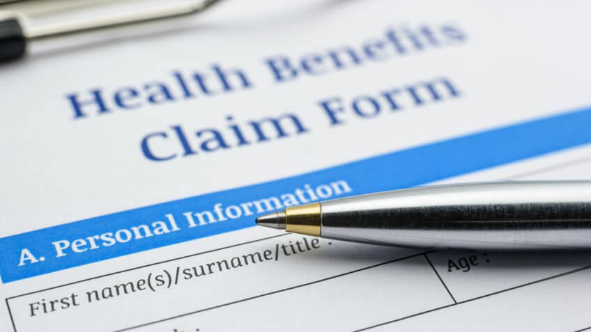 close-up of pen on top of health benefits claim form