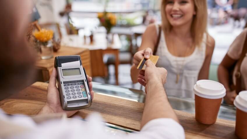 Customer paying for their order with a credit card in a cafe.