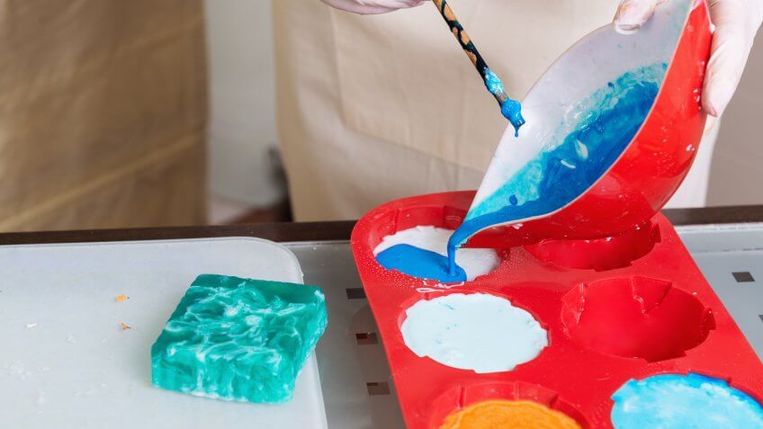 Homemade soap preparation, close up of form filling up.