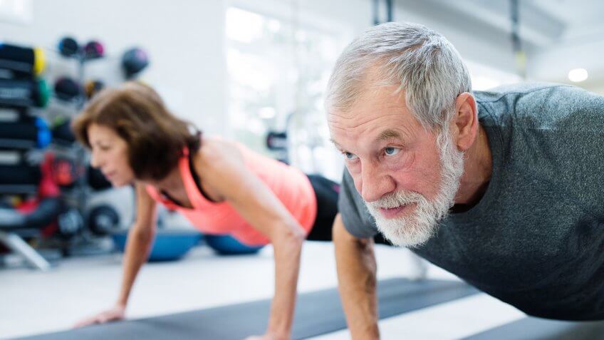 senior-couple-exercising-in-gym-healthy
