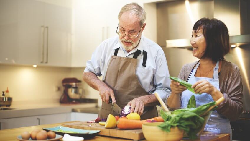 mature man and woman cooking in kitchen