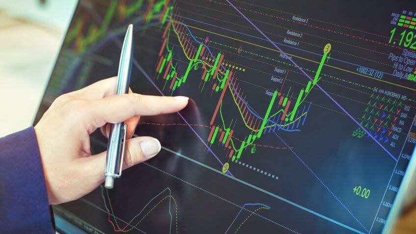 person pointing at stock market chart
