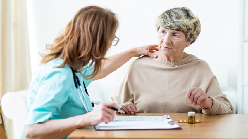 View of female doctor diagnosing elder woman.