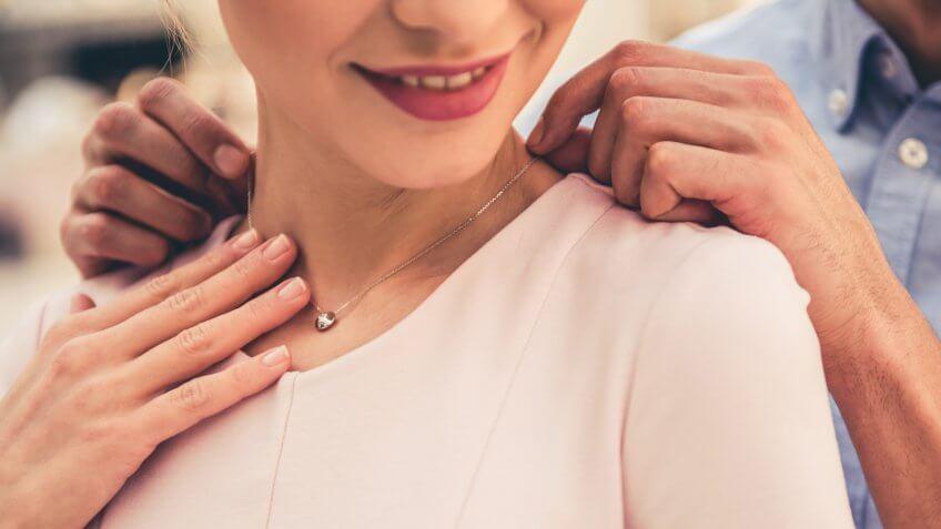 Cropped image of beautiful couple smiling while choosing jewelry in the shopping mall.