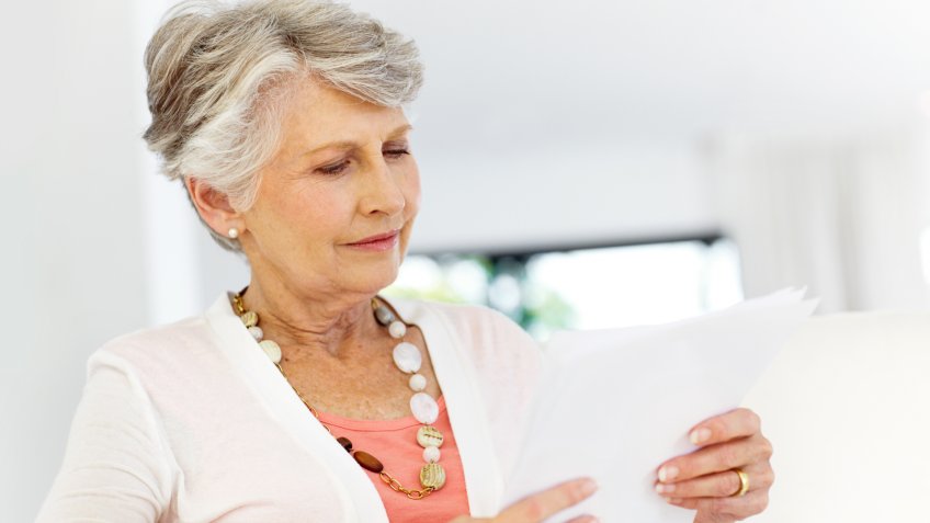 Senior woman reading over some documents.