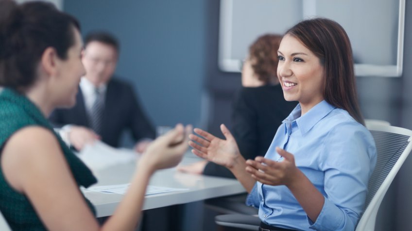 Women talking together in business office meeting.