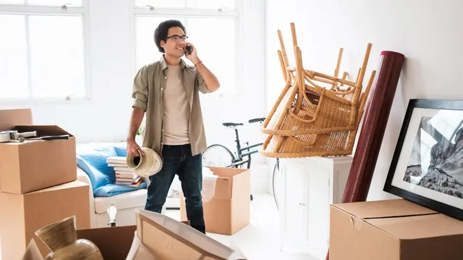 Mixed race man unpacking in new home.