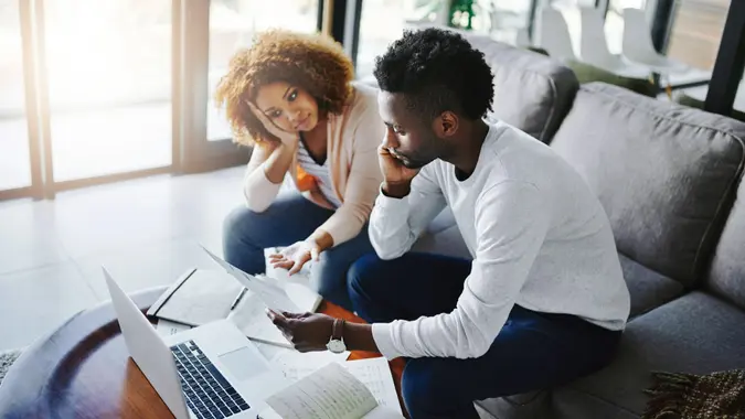 Shot of a young couple looking anxious while doing their budget at home.