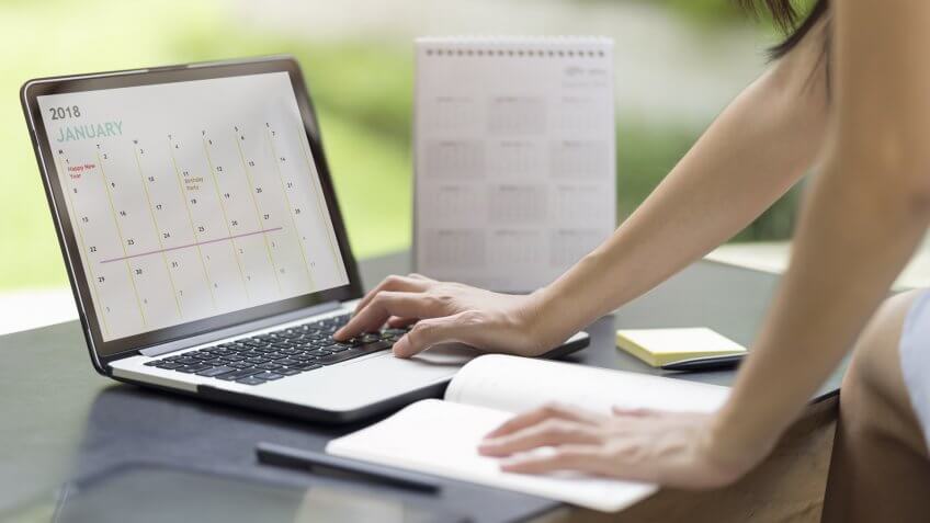 Woman planning agenda and schedule using calendar event planner.