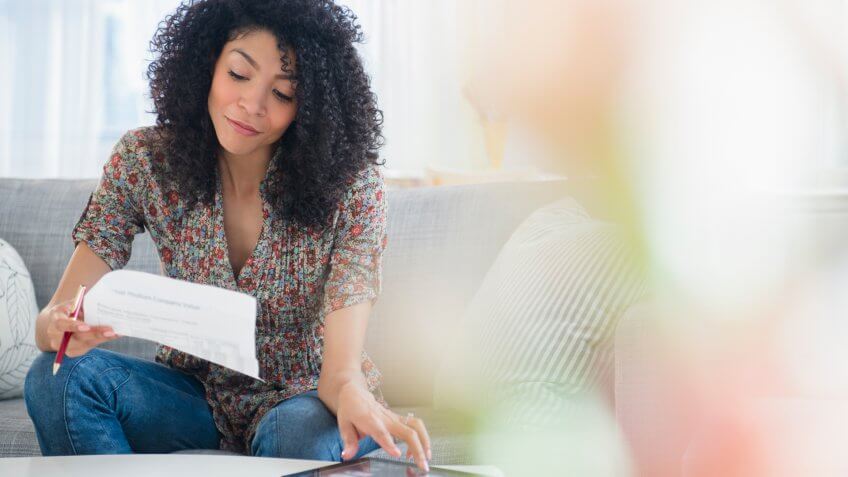 young woman looking at a monthly bill