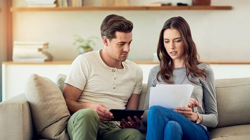 Shot of a young couple going through their paperwork together at home.