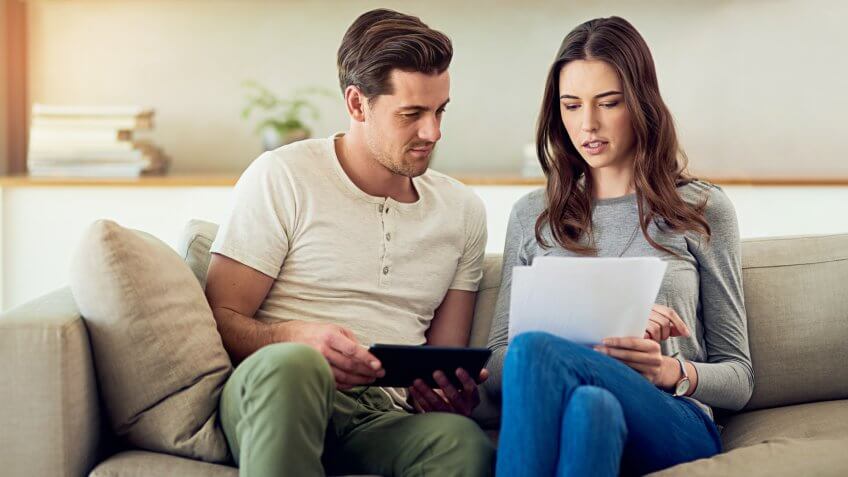 Shot of a young couple going through their paperwork together at home.