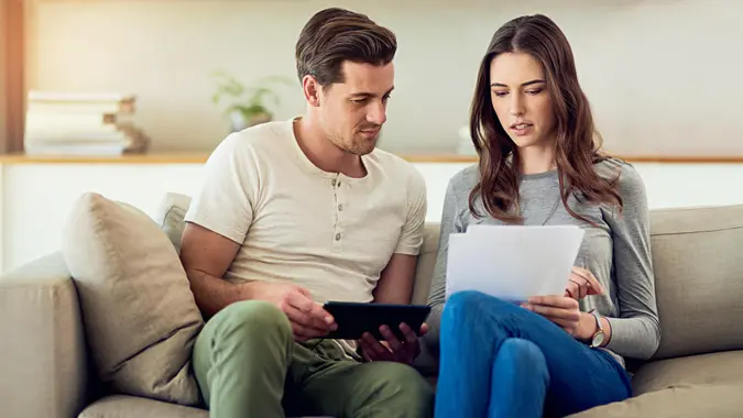 Shot of a young couple going through their paperwork together at home.