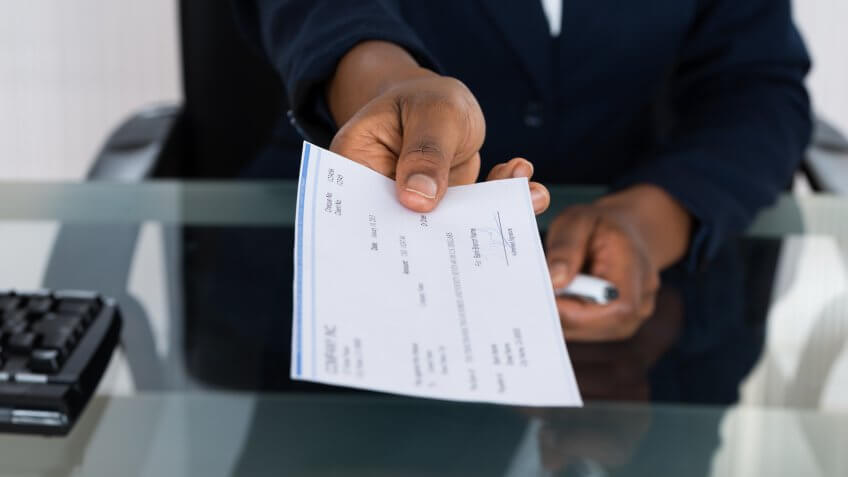 Close-up Photo Of Person's Hand Giving Cheque.