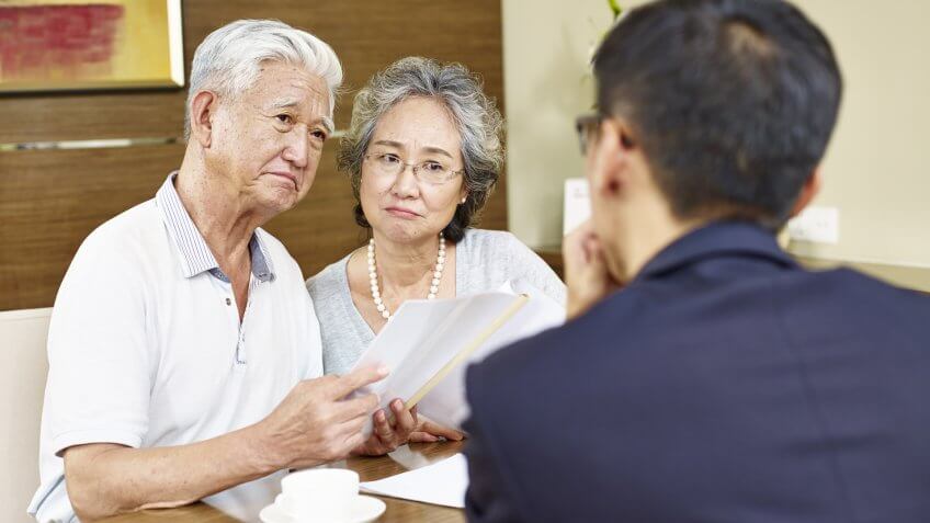 elderly couple talking to financial expert