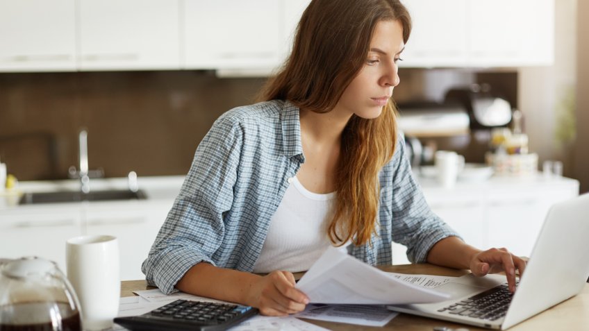 young woman sorting through paper work to file taxes