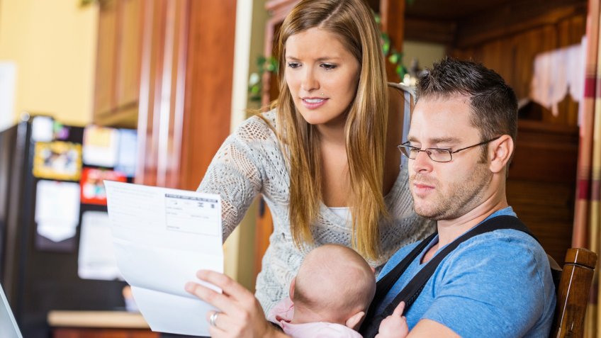 Father holding sleepy baby while he works from home.