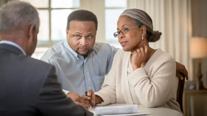 African American couple talking to businessman.