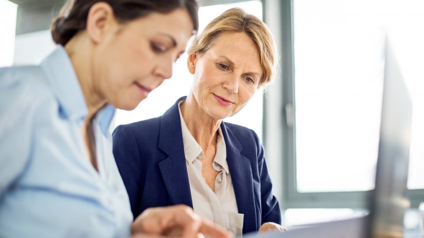Shot of a senior business manager presenting financial data to her colleague during a meeting.