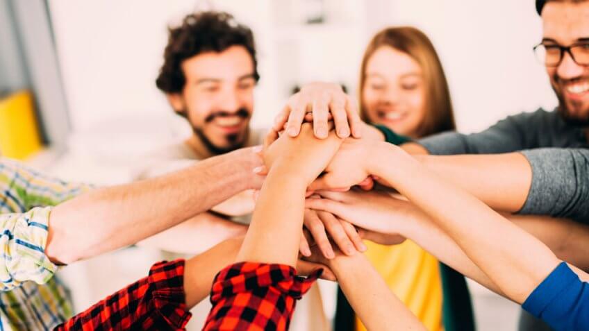 A group of friends putting their hand one over another.