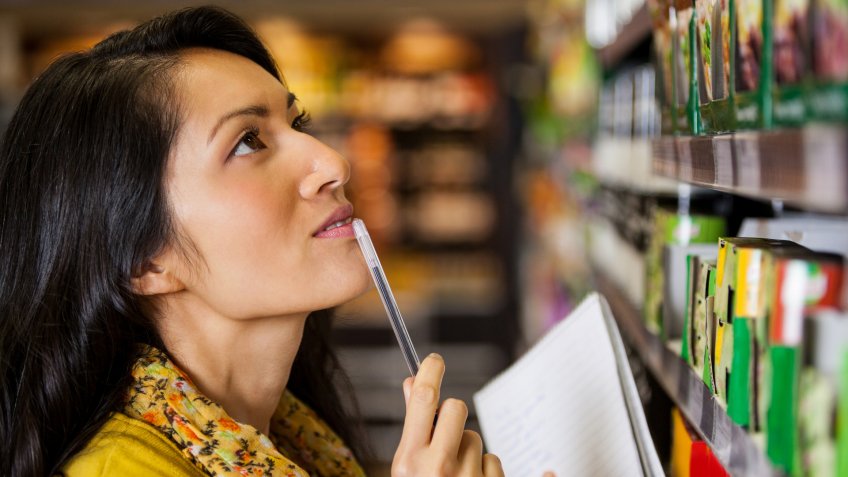 Thoughtful woman shopping for grocery in supermarket.