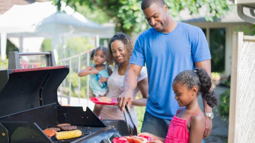 A family of four are outside on a beautiful sunny summer day.