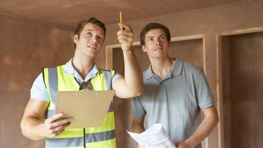 Builder And Inspector Looking At New Property.